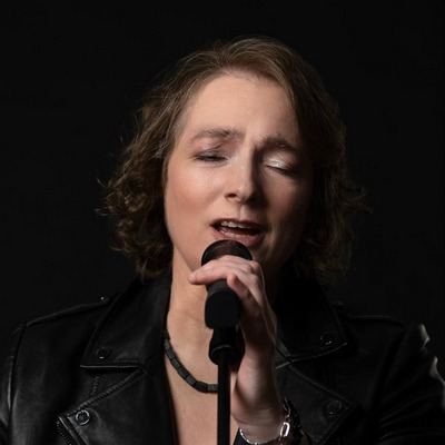 Bild von Julia Wörlein emotional und laut singend am Mikrofon